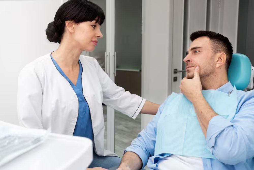 dentist checking patient’s jaw during tmd evaluation and discussing jaw pain treatment options