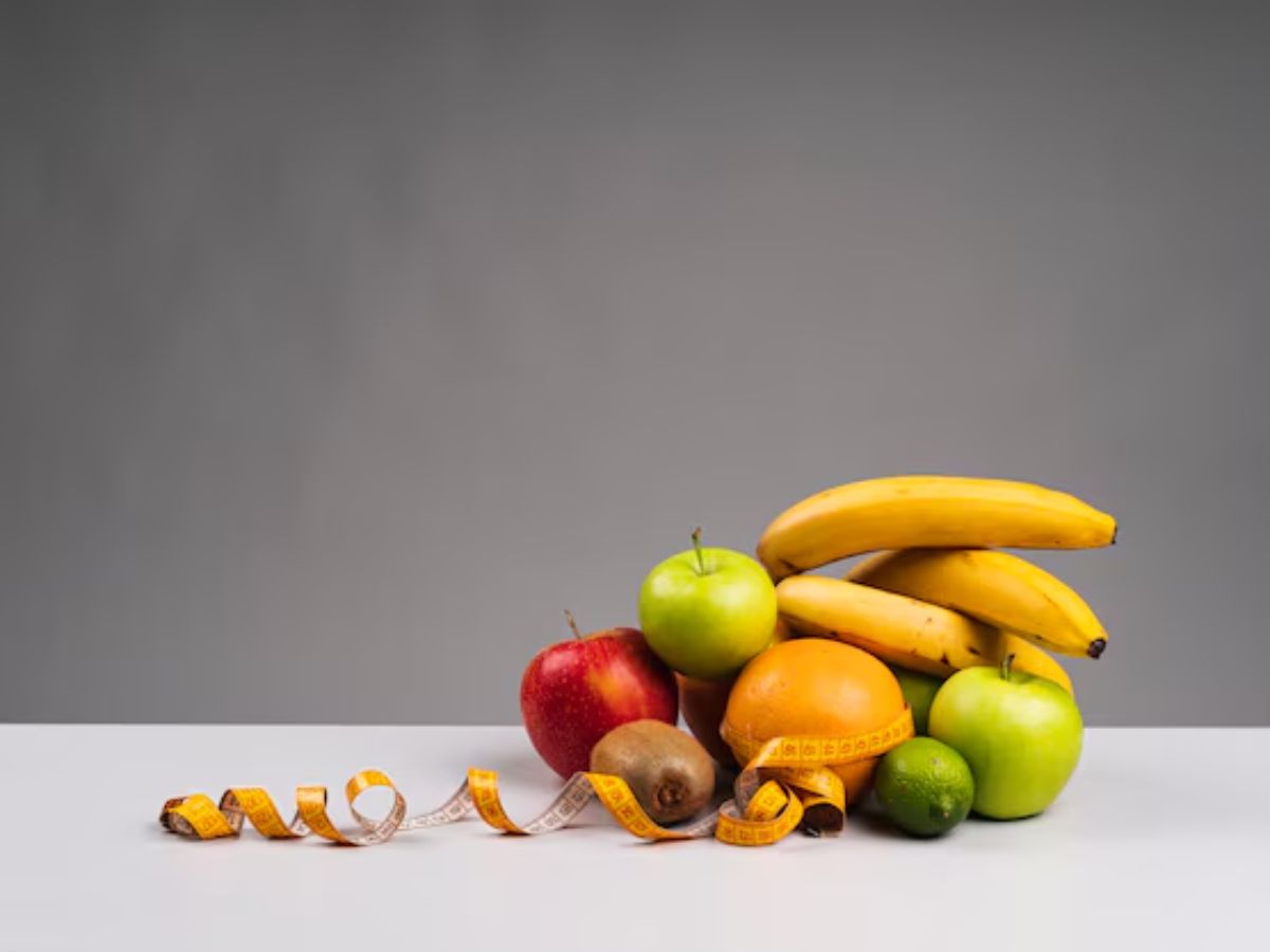 fresh fruits including apples, bananas, kiwi, and oranges representing healthy food choices after tooth extraction