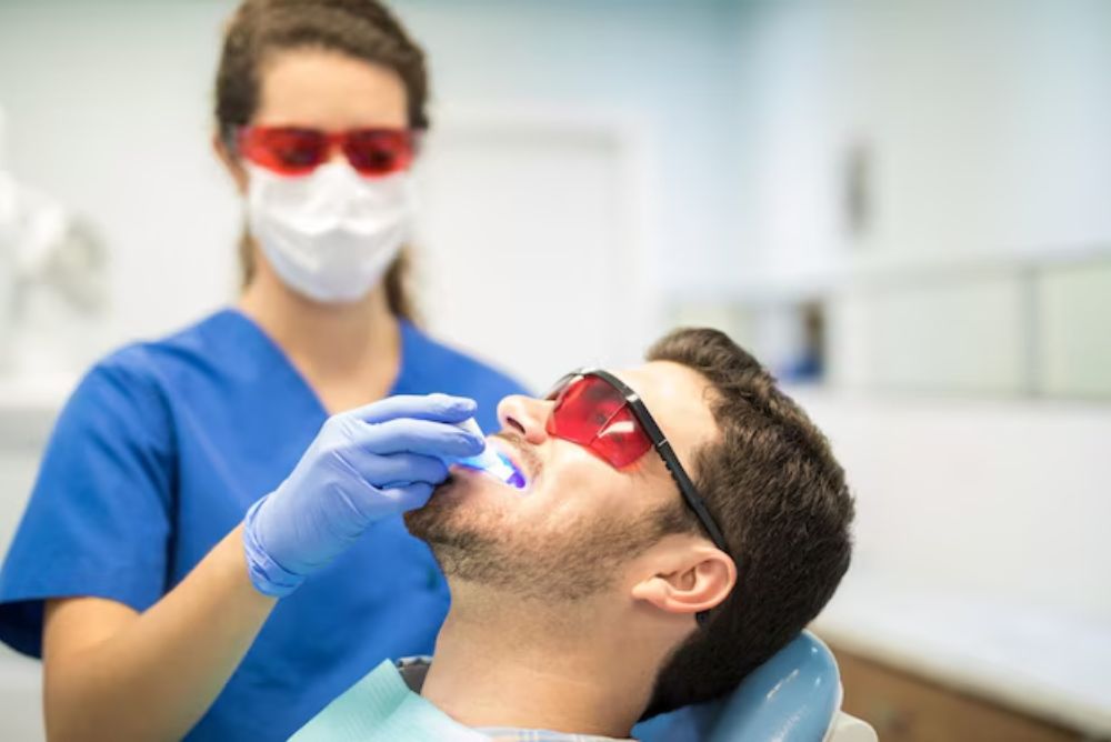 dentist performing teeth whitening treatment